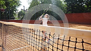 Coacher teaching young girl to playing tennis.