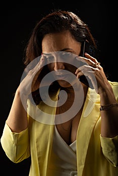 Coaching woman, wearing yellow outfit, talking on cell phone. Communicative and motivational management