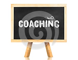 coaching word and key icon on blackboard with easel and reflection on white background,Business concept