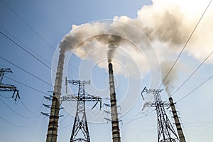 Coal burning industrial power plant with smoke stacks. Dirty smoke on the sky, ecology problems.