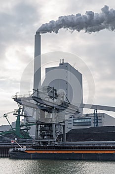 Coal-fired power plant with chimneys, ship and slagheap