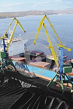 Coal is loaded into the holds of a dry cargo ship in the seaport 24 hours a day.