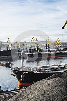 Coal is loaded into the holds of a dry cargo ship in the seaport 24 hours a day.