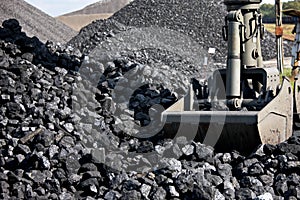 Coal loading excavator, heaps of coal