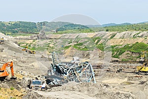 Coal mine accident with a heavy extraction machine inside the coal exploitation. The huge excavator collapsed in the open pit.