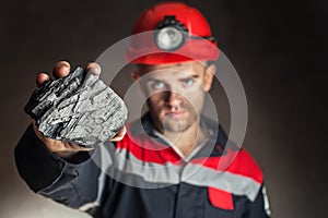 Coal miner showing lump of coal