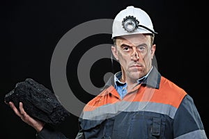 Coal miner showing lump of coal with thumbs up