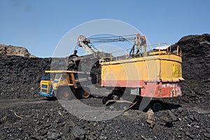 Coal mining. The dredge loads the truck coal. photo