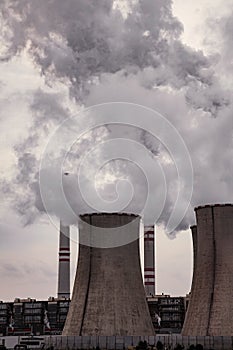 Coal power plant polluting environment and chimneys smoking  towards the sky.