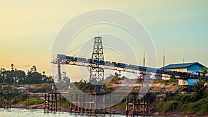 Coal stockpile on riverbank at dawn