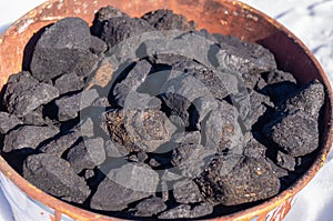 Bucket with black coke charcoal for heat