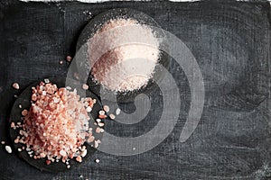 Coarse and fine Himalayan salt on a black background