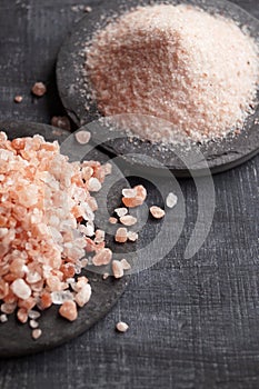 Coarse and fine Himalayan salt on a black background