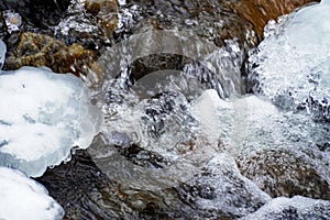 Coarse flowing water, frozen current, winter brook