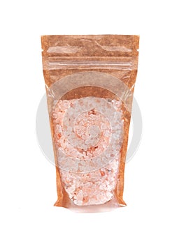 Coarse Himalayan salt in a brown paper bag. Doy-pack with a plastic window for bulk products. Close-up. White background. Isolated
