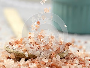 Coarse pink salt falling onto spoon