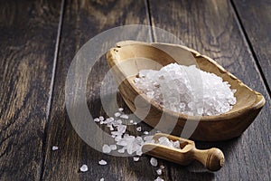 Coarse salt with scoop in wooden bowl