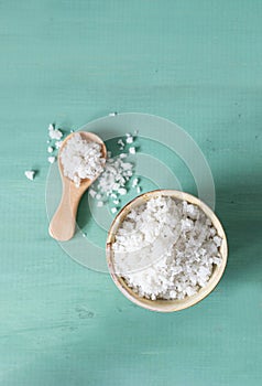 Coarse salt on a turquoise wooden background.