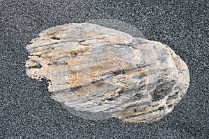 Coarse sand around stone on beach