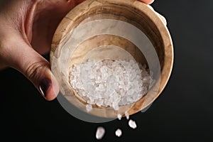 Coarse sea salt crystal falling from bowl photo