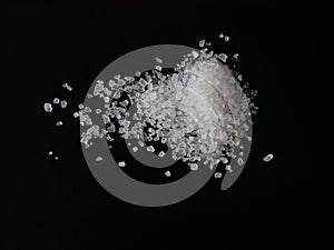 Coarse sea salt crystals isolated on black background close up