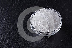 Coarse sea salt on a dark stone background