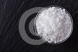 Coarse sea salt on a dark stone background