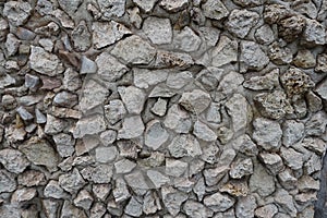 Coarse surface of wall with light gray gravel pebble dash