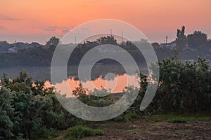 Coast of calm flat river at dawn