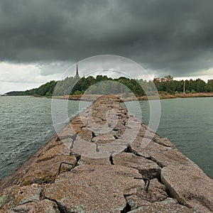 coast of the city of Primorsk in the Leningrad region with the Kirkha spire from the Stone Pier. On a summer cloudy