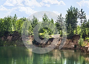 Coast forest lake with crystal clear water, which reflects the trees, beautiful prorodny landscape blue sky