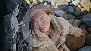 Coast girl posing rocks on beach closeup. Serene beautiful woman with braids