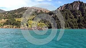 Coast of green mountain river view from boat in Patagonia Argentina.