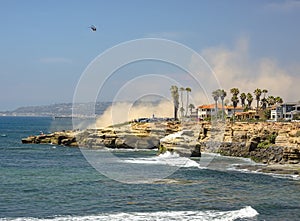 The coast of La Jolla with a helicopter in the sky