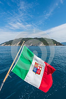 the coast of Liguria seen from the boat with the Italian flag