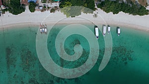 Coast with parked boats by beach. Yachts and gondolas parked by sandy tropical seashore or ocean. Top view from drone