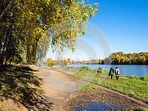 coast of pond in urban park in sunny autumn day photo