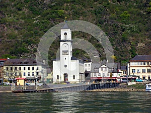 Coast of the Rhine, Germany, wide fast river, many beautiful houses, mountain slopes, blue sky, spring greenery