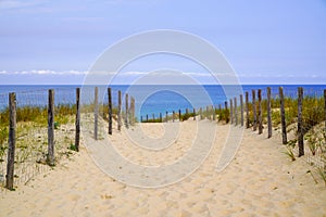 Coast water access sand dune pathway fence to ocean beach atlantic coast in Cap-Ferret in France