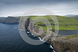 Coast, waterfall and cliffs at TrÃ¦lanÃ­pa on the island of Vagar, with Lake Leitisvatn, Faroe Islands photo