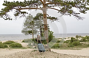 On the coast of the White Sea, a girl swinging on a swing.