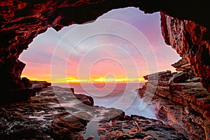 Coastal cave views to glorious sunrise over the ocean photo