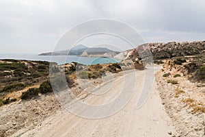 Coastal dirt road along Aegean sea on Milos island, Greece