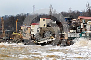 Coastal erosion - houses built on weak clay soil slide down to the sea and collapse