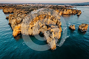 Coastal golden cliffs at sunrise in Ponta da Piedade near Lagos,Portugal.Spectacular rock formations with caves,and sea arches,
