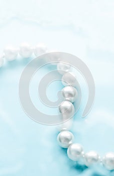 Coastal jewellery fashion, pearl necklace under blue water background, glamour style present and chic gift for luxury jewelery