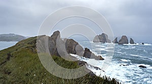 Coastal landscape with steep cliffs and rock formations carved out by wave action