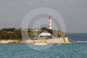 Coastal lighthouse on the edge of a rocky promontory in the black sea, the city of Gelendzhik. Located to the left of the frame.