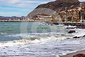 Coastal maritime landscape with waves crashing on sand on beach