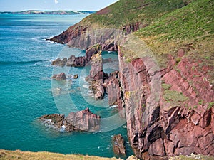 Coastal red cliffs near Manorbier in Pembrokeshire, Wales, UK